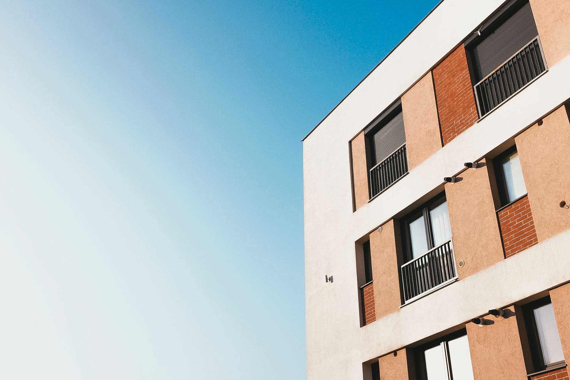 A condo building with a blue sky behind it