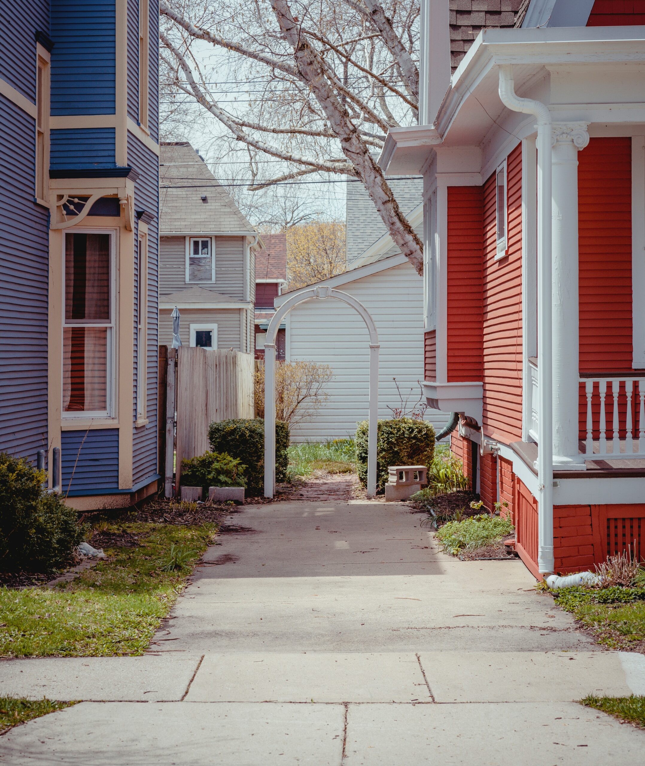 A view of a shared driveway between a blue house and a red house