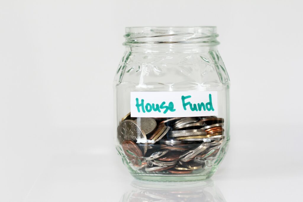 A jar of coins labelled House Fund